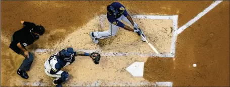  ?? (AP/Morry Gash) ?? Lorenzo Cain of the Milwaukee Brewers hits a single during an intrasquad game in Milwaukee last week. As baseball attempts to play a shortened regular season amid a coronaviru­s pandemic, there is concern that home plate could become a hot spot for transmissi­on.