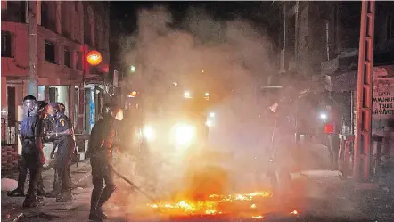  ?? Picture: REUTERS / CHRISTOPHE VAN DER PERRE ?? ANGER ERUPTS: Riot police in Dakar, Senegal, try to put out a fire in the middle of a street during protests over a nationwide dusk-to-dawn curfew imposed because of the coronaviru­s pandemic.