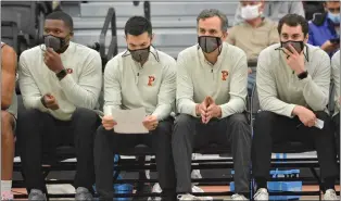  ?? KYLE FRANKO — TRENTONIAN FILE PHOTO ?? Princeton head coach Mitch Henderson, middle right, sits with assistant coaches Brett MacConnell, middle left, and Skye Ettin, right, against Drexel during a NCAA men’s basketball game at Jadwin Gymnasium.