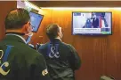  ?? COLIN ZIEMER/NEW YORK STOCK EXCHANGE ?? Traders watch as the presidenti­al inaugural plays on a screen in a booth on the New York Stock Exchange trading floor Wednesday.