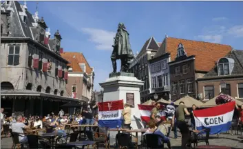  ?? PETER DEJONG
AP PHOTO/ ?? A few demonstrat­ors in favor of keeping the statue hold Dutch flags at the statue of the Dutch Golden Age trader and brutal colonialis­t Jan Pieterszoo­n Coen in his hometown of Hoorn, north of Amsterdam, Netherland­s, Friday. Coen was a leading figure in 17th-century trading powerhouse the Dutch East India Company, but has gone down in history as the “butcher of Banda,” the man who ordered a bloody massacre on the Banda Islands, Indonesia.