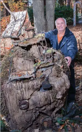  ?? WILLIAM HARVEY/TRILAKES EDITION ?? Jerry Lewis is the Volunteer of the Year at Garvan Woodland Gardens in Hot Springs. He has created a fairy village using old stumps found in the gardens. The fairy apartment pictured here with Lewis is topped with a honeymoon suite.