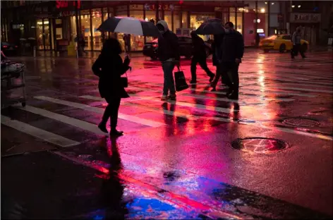  ?? AP PHOTO/MARK LENNIHAN ?? Shoppers walk in a rainstorm, Monday, in New York.