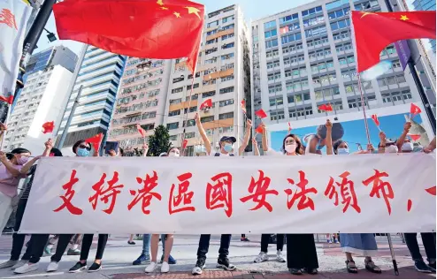  ??  ?? 30 de junio de 2020. Ciudadanos de Hong Kong salen a la zona de Causeway Bay para apoyar la ley de seguridad nacional y cantar el himno nacional.