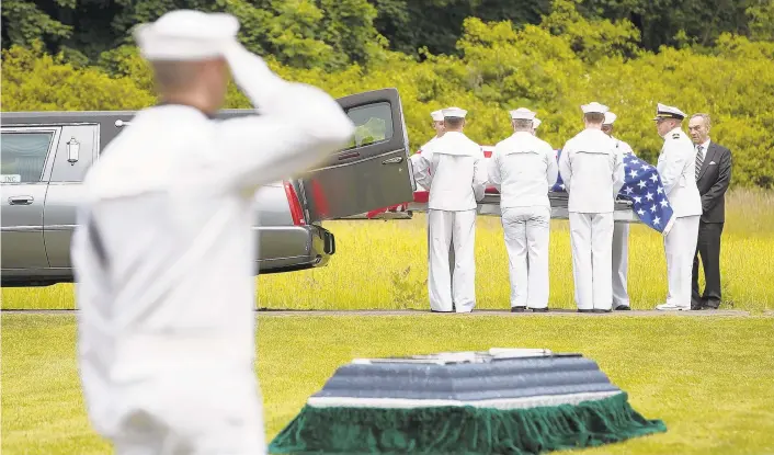  ?? CHRISTOPHE­R DOLAN/AP FILE PHOTO ?? A casket containing the remains of U.S. Navy Seaman 1st Class Edward Slapikas, a Newport Township native killed while serving aboard the USS Oklahoma in the Japanese attack on Pearl Harbor in December 1941, is taken from a hearse during a burial service at St. Mary's Cemetery in Nanticoke, Luzerne County. Slapikas' remains were identified this year and returned to Luzerne County for burial 77 years after his death.