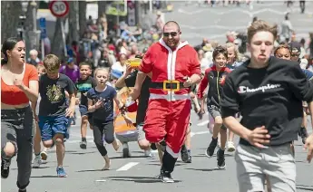  ??  ?? The regional manager of Zeal Taranaki, Luke Galley, in the Santa suit, races the kids in the Santa Sprint.