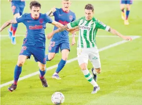  ?? — Gambar AFP ?? SENGIT: Pemain pertahanan Atletico Madrid Stefan Savic (kiri) bersaing dengan Cristian Tello pada perlawanan La Liga Sepanyol di antara Real Betis dan Club Atletico de Madrid di stadium Benito Villamarin di Seville, kelmarin.