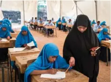  ??  ?? Nasra Nuh Hassan administer­s exams at Hagadera Secondary School, where she has worked with Ayan Abdi as a teacher.