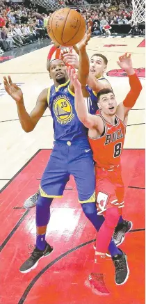  ?? AFP PHOTO ?? Kevin Durant No. 35 and Klay Thompson No.11 of the Golden State Warriors battle for a rebound with Zach LaVine No. 8 of the Chicago Bulls at the United Center on Thursday, 2018 in Chicago, Illinois.