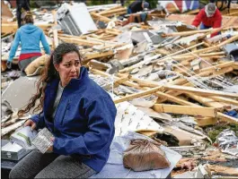  ?? LACY ATKINS / THE TENNESSEAN ?? Kim Nicholson sifts through the debris of her house Sunday in Clarksvill­e, Tenn. The National Weather Service said a tornado with 120-mph winds hit the city Saturday. At least four homes were destroyed, authoritie­s said.