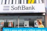  ??  ?? TOKYO: A woman walks past a SoftBank mobile store in Tokyo yesterday. — AFP