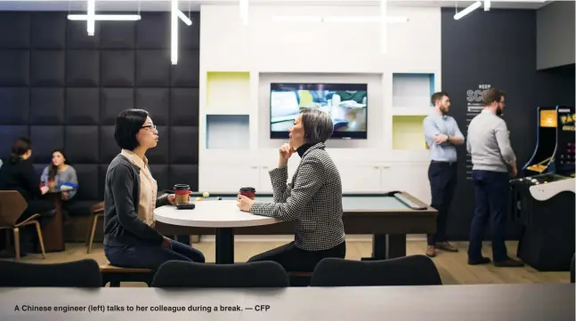  ??  ?? A Chinese engineer (left) talks to her colleague during a break. — CFP