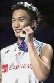  ??  ?? Proud time: Kento Momota of Japan posing with his gold medal after beating Shi Yuqi of China in the final of the men’s singles event yesterday.