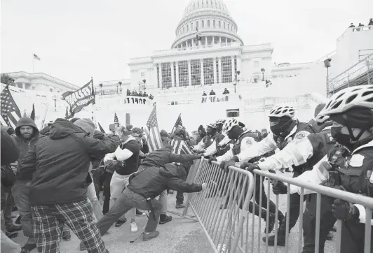  ?? JULIO CORTEZ/AP ?? Pro-Trump protesters try to break through a police barrier Wednesday at the U.S. Capitol. The mob was able to breach security and make it inside the building.