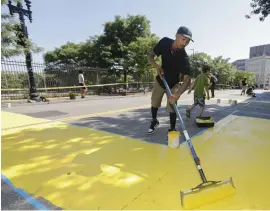  ??  ?? A MURAL THAT MATTERS: Mar Deuno paints the letter L as part of a Black Lives Matter sign painted in Nubian Square.