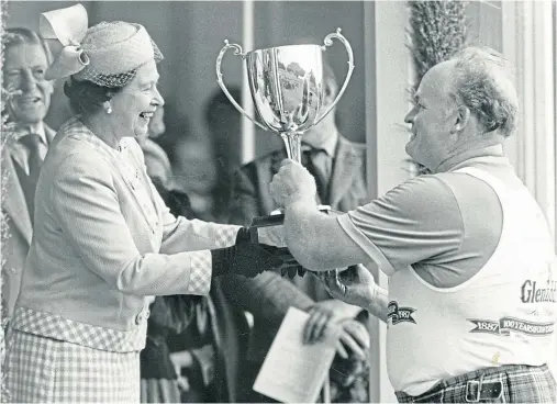  ??  ?? GLORY: The Queen presents a trophy to Bill Anderson at the Braemar Gathering in September 1987