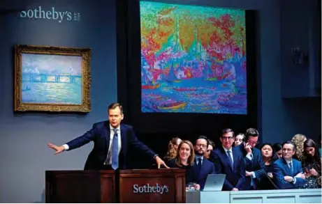  ??  ?? Sotheby’s auctioneer Oliver Barker takes bids on the painting by Paul Signac titled ‘La Corne d’Or’ (Constantin­ople) during an auction in New York City. — AFP photos