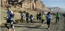  ?? AFP ?? BAMIYA: This file photograph taken on November 4, 2016 shows Afghan and internatio­nal marathon runners taking part in a marathon on a course that took participan­ts past the destroyed Buddha statues in Bamiyan province. Crossing the finish line of...