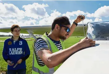  ??  ?? Preflight checks: Nicholas (left) watching as Pemmiredy performs technical and safety checks before a flight over London in a Cessna 172 plane at the London North Weald airfield. — AFP