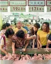  ?? CHINA STRINGER NETWORK ?? Customers select meat at a supermarke­t in Hangzhou.