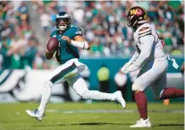  ?? MATT SLOCUM/AP ?? Eagles quarterbac­k Jalen Hurts is pressured by Commanders defensive tackle Daron Payne on Oct. 1 at Lincoln Financial Field.