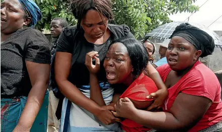  ?? AP ?? A family member of Kelvin Tinashe Choto reacts during his funeral in Chitungwiz­a, about 30km south east of the capital, Harare. Before the family of Kelvin Tinashe Choto knew he had been killed, social media in Zimbabwe was circulatin­g a photo of his battered body lying on the reception counter of a local police station.