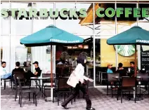  ??  ?? A woman walks past a Starbucks Coffee shop in Rawang outside Kuala Lumpur on Thursday. (AP)