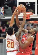  ?? David Goldman / AP ?? Atlanta’s John Collins (20) is fouled by Toronto’s Serge Ibaka during the third quarter Wednesday’s game in Atlanta. Toronto won 108-93.