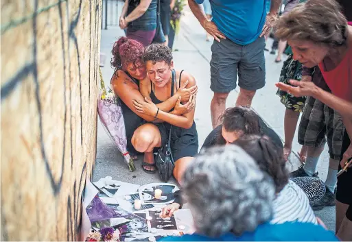  ?? MARK BLINCH/THE CANADIAN PRESS ?? Desirae Shapiro, a friend of 18-year-old Danforth shooting victim Reese Fallon, and her mother Gina Shapiro visit a makeshift memorial on Tuesday.