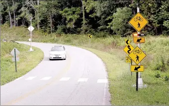  ?? Kent Marts/The Weekly Vista ?? Flashing lights warn drivers that someone may be on the bike trailing attempting to cross Trafalgar Road at Pinion Creek. Motorist traveling north on Trafalgar are coming down a steep hill while rounding a corner when the crossing springs into view.