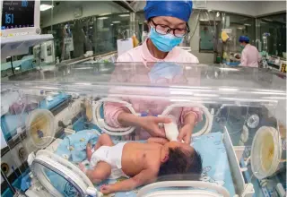  ?? Photo by AFP ?? This file photo taken on May 12, 2023 shows a nurse taking care of a newborn baby at a hospital in Taizhou, in China’s eastern Jiangsu province.