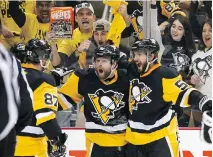  ?? JUSTIN K. ALLER/GETTY IMAGES ?? Phil Kessel of the Pittsburgh Penguins, centre, celebrates his goal against the Washington Capitals.