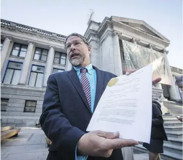  ?? DARRYL DYCK/THE CANADIAN PRESS ?? The David Suzuki Foundation’s Jay Ritchlin holds a copy of a lawsuit filed regarding the protection of southern resident killer whales.