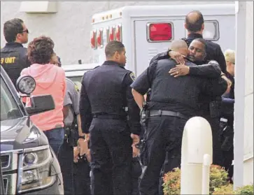  ?? Photograph­s by Laura A. Oda Associated Press ?? LAW ENFORCEMEN­T officers gather at Eden Medical Center in Castro Valley, Calif., where Hayward Police Sgt. Scott Lunger was taken after he was shot. He was pronounced dead at the hospital.