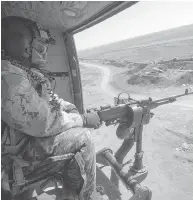  ?? RYAN REMIORZ / THE CANADIAN PRESS FILES ?? A Canadian Forces door gunner keeps watch as his Griffon helicopter goes on a mission in northern Iraq.