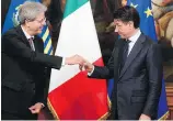  ?? CLAUDIO PERI, ANSA VIA AP ?? Outgoing Italian premier Paolo Gentiloni, left, hands the cabinet bell to his successor, Giuseppe Conte, during a ceremony in Rome on Friday.