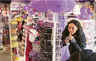  ?? Seth Wenig / Associated Press ?? Sarah Hu shops at a Claire's in New York last weekend. The chain says it is much healthier than fellow retailers that have filed for bankruptcy. It said it wanted to restructur­e its balance sheet.