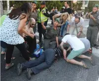  ?? (Marc Israel Sellem/The Jerusalem Post) ?? POLICE TREAT the wounded on Keren Hayesod Street after they were stabbed by a haredi man during the annual Jerusalem Gay Pride Parade.