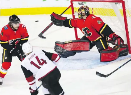  ?? AL CHAREST ?? Calgary Flames goaltender Mike Smith extends the blocker to redirect a shot by Arizona Coyotes forward Richard Panik out of harm’s way, one of 22 saves Smith made in a 7-1 victory over his former team during Sunday night’s game at the Scotiabank Saddledome.