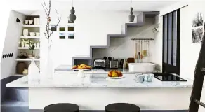  ??  ?? In this studio apartment, an architect designed a fully functionin­g kitchen that is tucked under the stairs.