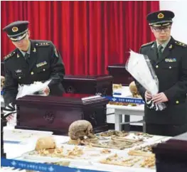  ??  ?? Chinese military officers lay flowers near the remains of Chinese soldiers, who fought during the Korean War, during ceremonial rites to place the remains at a temporary military ossuary in Incheon, west of Seoul, yesterday. The remains of 28 Chinese...