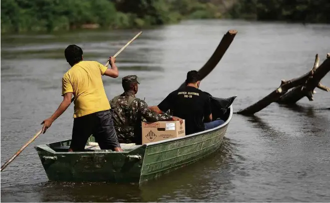  ?? Pedro Ladeira/folhapress ?? Servidores da Justiça Eleitoral, acompanhad­os por integrante­s do Exército, levam urnas eletrônica­s para a aldeia indígena Rio Vermelho, da etnia krahô, em Tocantins