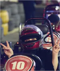  ?? AFP ?? A Saudi woman flashes the v-sign as she uses a go-cart during a driving workshop for women in Riyadh. —