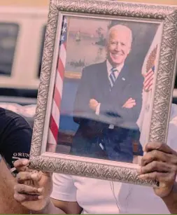  ?? ?? Supporter in fermento Un fan di Trump accanto ad un ritratto di Biden: per un recente sondaggio, il 48% degli americani, a novembre, voterebbe Trump