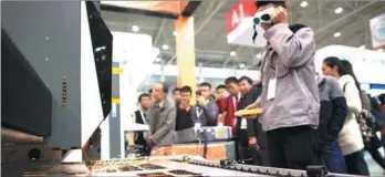  ?? XIONG QI / XINHUA ?? A worker showcases a laser cutting machine at the 13th Optics Valley of China Internatio­nal Optoelectr­onic Exposition and Forum in Wuhan, Hubei province, in November.