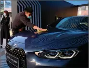  ??  ?? A worker polishes a car during a promotion Sunday in Beijing. China’s sales of vehicles rose in October.
(AP/Ng Han Guan)