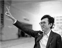  ??  ?? Ng makes a victory sign as he walks out of a Hong Kong courthouse. — AFP photo