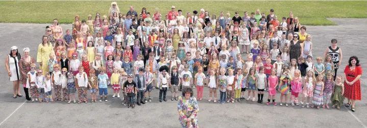  ?? PICTURES: PHIL DAVIES / SCENIC GALLERY ?? The pupils and staff at Porthcawl Primary went back to the 1960s to celebrate the school’s 50th anniversar­y and the retirement of head teacher Andrew Wood