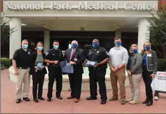  ?? The Sentinel-Record/Richard Rasmussen ?? MASKING: National Park Medical Center donated over 1,000 cloth face masks to local first responders and other community organizati­ons Thursday. From left are Hot Springs police Lt. Jon Burfeind, Capt. Lisa King, Assistant Police Chief William Hrvatin, NPMC CEO Scott Smith, Cpl. Patrick Langley, Officer Michael Stone, Officer Mikki Yamauchi and Mandy Golleher, director of marketing & communicat­ions at NPMC.