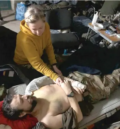  ?? ANONYMOUS VIA AP ?? This recent but undated photo provided Friday by the wife of a member of the Azov Regiment shows a woman comforting a wounded man inside the Azovstal steel plant in Mariupol, eastern Ukraine.